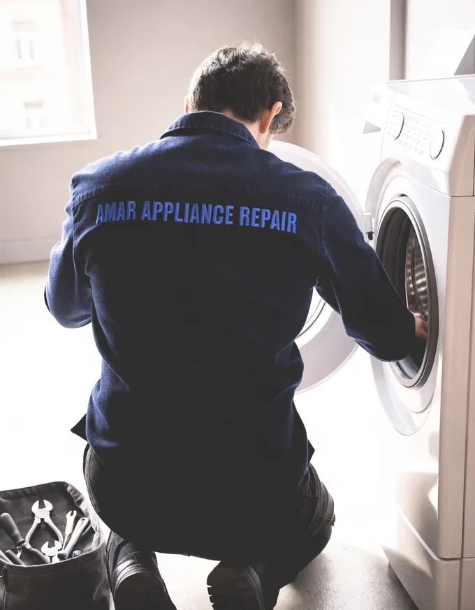 Amar Appliance Repair technician working on an open front-load washer